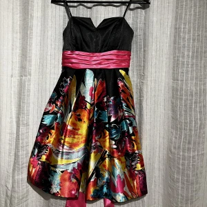 Kort finklänning  - Färgstark cocktailklönning utan axelrämmar med rosett på ryggen. Använd en gång.