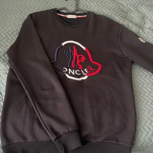 Moncler tröja - Säljer denna svarta moncler tröjan för endast 375kr. Jag säljer pågrund av att jag har vuxit ur den. Säljer den för billigt eftersom jag vill bara bli av med den fort.