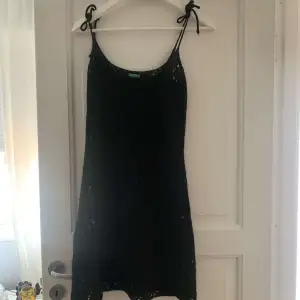 Snygg svart stickad klänning men knutna band 