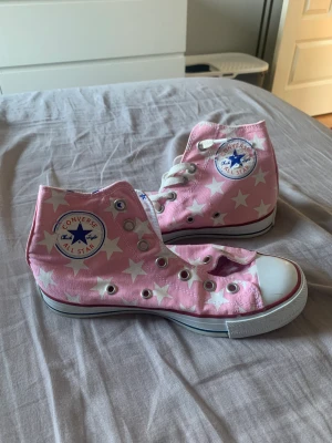 Converse  - Rosa converse med stjärnor, något slitna men i bra skick, snöre finns till båda men har tagit ut det ena, sätter självklart i de vid köp. Stl 38, 100kr + frakt, men pris kan diskuteras🩷
