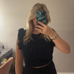 Svart topp från zara  - Svart topp från zara med volanger på axlarna  Knappt använd  Storlek m bra passform 