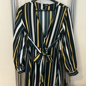 Klänning - Knäppbar klänning med medföljande knytband Ca knälång