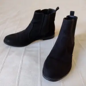 Svarta boots i mockaimitation. Stilrena och lätta skor som är väldigt användbara. Sparsamt använda (passar tyvärr inte mig annars hade jag behållit dem). Storlek 40. Några repor i fram.  