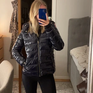 Puffjacka Tommy Hilfiger - Glansig, mörkblå puffjacka ifrån Tommy Hilfiger. Köpt för kanske 2400 för två vintrar sen. Superskön och snygg. ☺️