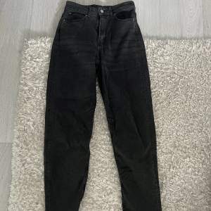 Ett par svart/grå jeans som är rak i benen och inte kommer till användning längre 