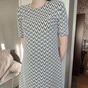 Tunika / klänning - Välanvänd men jättefin svart -vit mönstrad klänning / tunika från H&M Divided. Längd 80 cm. Den är gjort i ett lite tjockare "vävt" material som gör att det blir väldigt fint rakt fall. 79 % polyester, 18 % viskos och 3 % elastan.