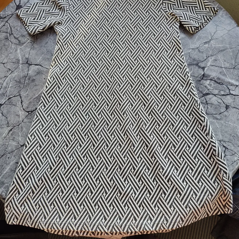 Välanvänd men jättefin svart -vit fiskbensmönstrad klänning / tunika H&M Divided. Ljusbrun pyttefläck på magen. Dragkedja bak. Längd 80 cm. Lite tjockare 