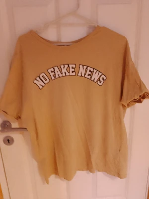 Tshirt  - En brun/beige snygg tshirt med no fake news tryck. 💗Säljer den då den sällan kommer till användning.