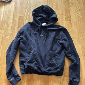 Säljer en oanvänd mörkblå hoodie med vita sömmar och detaljer, från märket holzweiler i storlek Small.