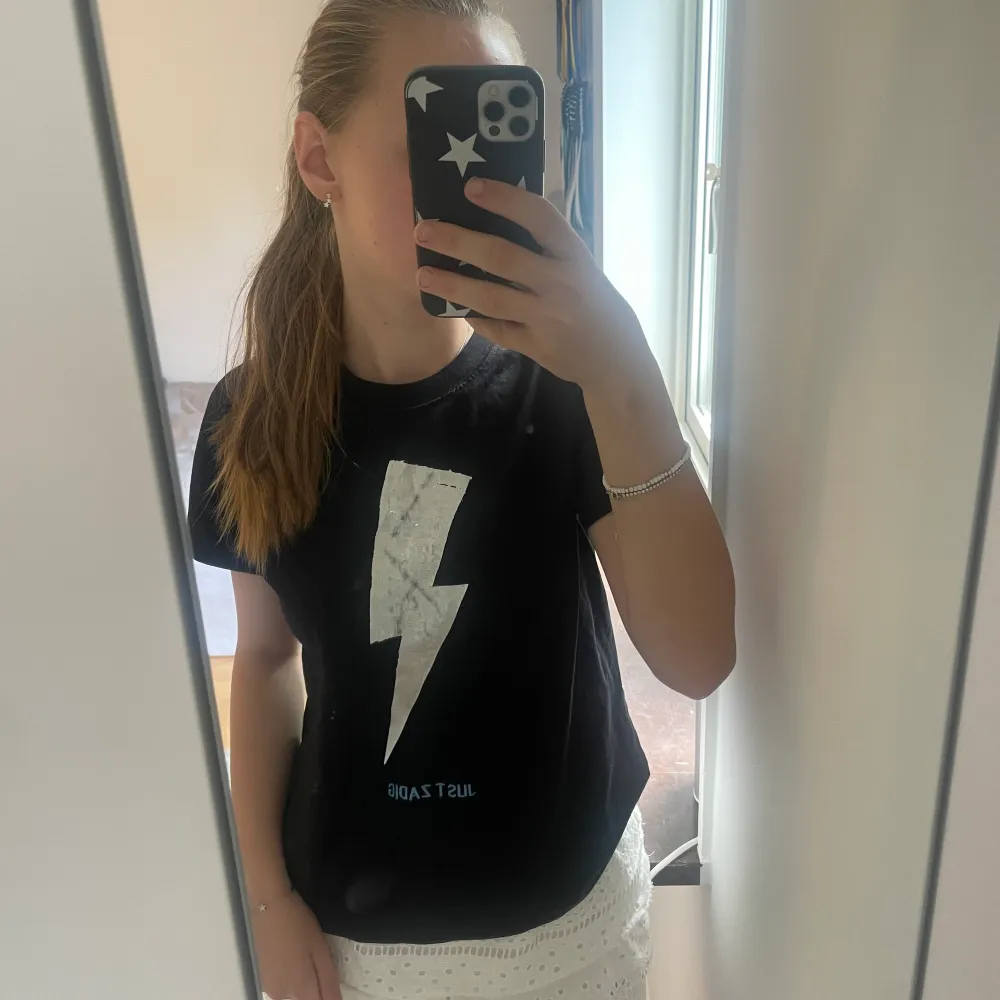 Säljer denna jättefina t-shirten från zadig! 💖 Använd men i fint skick men trycket har flagnat lite (kontakta för mer bilder på det). 🙌🏻 står att den är i strl 14/S men passar mig som har XXS-S i tröjor. 💞 säljs då den inte kommer till användning. nypris ca. 400kr. Frakt tillkommer, kontakta mig vid frågor mm. 🥰. T-paidat.