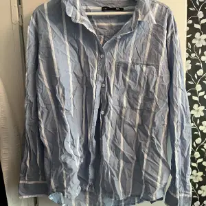 Strandskjorta i fin blå färg från Lager157. Passar både killar och tjejer.  Storlek L så jagvhaf använt den som en oversized skjorta till stranden.