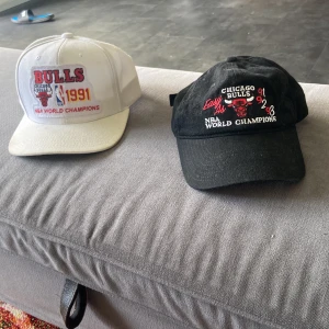 Michell and ness kepasr - Två stycken Mitchell and ness kepsar med Chicago bulls tryck på. Kan säljas var försig.  Båda 600kr och var försig 350kr