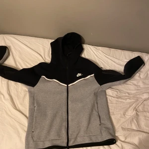 Nike tech fleece, black and grey - Säljer en grå och svart Nike tech fleece. Bara hoodien och den är använd 1 gång, säljer för att den var för liten för mig. Det är storlek L. Pris kan diskuteras