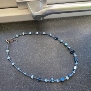 Halsband blåa stenar - Fint halsband med blåa stenar som är köpt second hand men inte kommer till användning