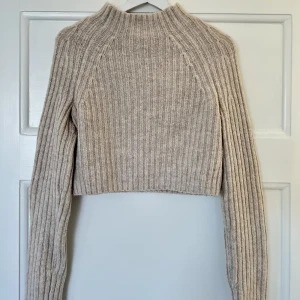 Stickad tröja - Jag säljer en beige croppad tröja från märket Monki i storlek S. Tröjan är väldigt liten i storleken så skulle säga att den passar någon som har storlek XS💕