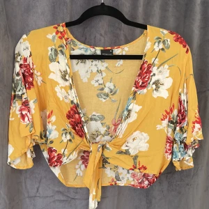 Topp GinaTricot - Blommig topp från ginatricot med knytning framtill. Är i storlek 36 men funkar även som 38! Använd endast en gång.