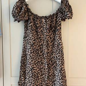Leopard klänning med puffärm från Nelly. Klänningen har markerade sömmar vid bröst.  Storlek 38 men passar en 36! Knäppning hela vägen.