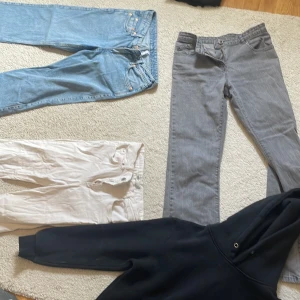 Kläder  - Säljer två par bootcut jeans i färgerna grå och vit. Sedan ett par blåa low waist arrow jeans ifrån weekday. En svart hoodie också. Säljer allt detta tillsammans för 250kr. 