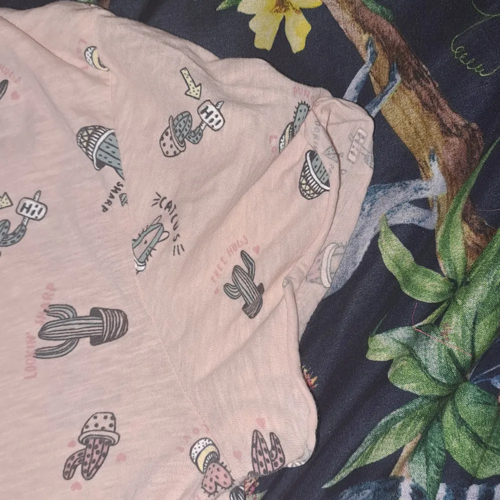 Rosa/begie kortärmad T-shirt från Kappahl med kaktus figurer på bak och framsidan använd ett par gånger 😊. T-shirts.