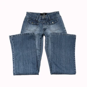y2k lågmidjade bootcut jeans - Skit coola lågmidjade y2k bootcut jeans med unika fickor på framsidan! Midjemåttet: 70cm Innerbenslängden: 80cm PS: kolla igenom mitt konto ni kommer hitta många y2k och vintage plagg!