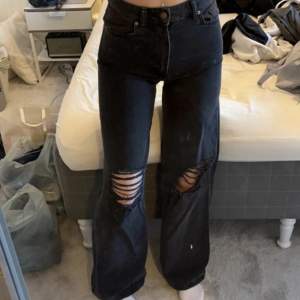 Svarta breda jeans med hål på knäna. Knappt använda, ser ut som nya. 