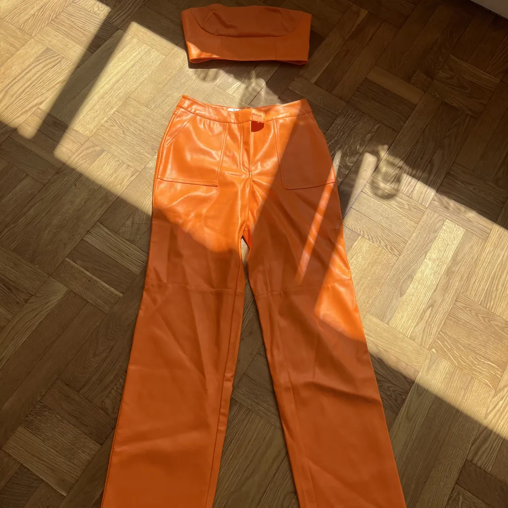 Ett supersnyggt orange skinnset från Elin Warnqvists kollektion med NAKD. Köpt hela setet för 1000kr totalt ca. Mitt pris 450kr. Endast använt en gång!  Byxor & topp strl 36. . Jeans & Byxor.