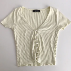 Topp med pärlknappar - Ljusgul/ljusbeige topp med pärlor som knappar.