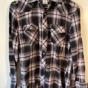 Vintage Wrangler flannel skjorta storlek medium. Finns tecken på användning i form av mindre slitage på vissa ställen, men annars i dugligt skick. Fler bilder kan så klart skickas vid behov!