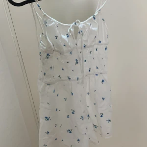 Vit sommarklänning  - Vit med blåa blommor på. Jättesöt och stretch i materialet. Aldrig använd. 
