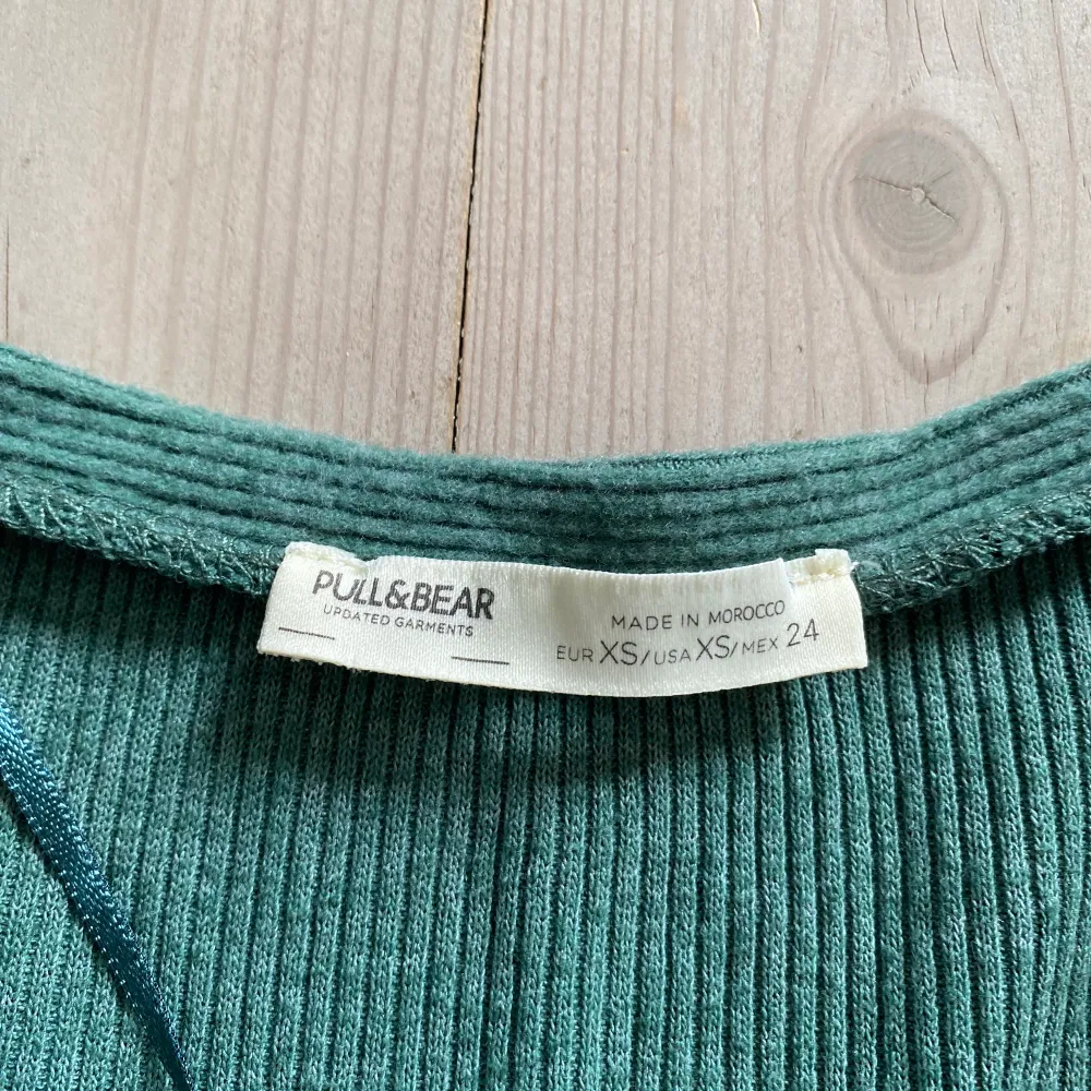Säljer en grön långärmad tröja från pull and bear i storlek xs, säljer på grund av att den är för liten. Använd en gång och är i väldigt bra skick, som ny. Köparen står för frakt!. Tröjor & Koftor.