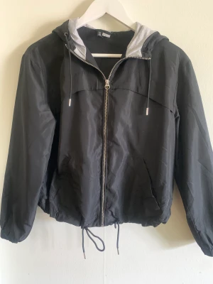 Jacka  - Svart tunn jacka med spännbara band, ganska gamal men i fint skick, storlek xs men stor i storleken 