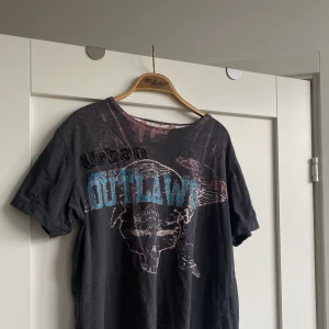 T-shirt - Cool T-shirt där de står ”Outlaws” på med glitter. Skitsnyggt street-style plagg!