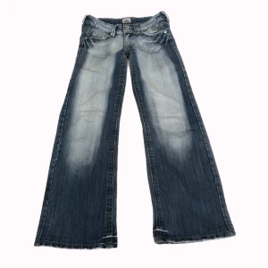 Y2K lågmidjade bootcut jeans - Så fina lågmidjade bootcut Y2K jeans! Midjemåttet: 38cm Innerbenslängden: 77cm PS. Kolla igenom mitt konto ni kommer hitta många y2k och vintage plagg! Det finns en fläck längst ner men det är inget som syns! 