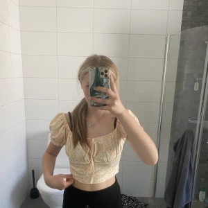 Gul blommig topp med puff armar och fin knytning - Ljusgul blommig topp med puffärmar och små blommor