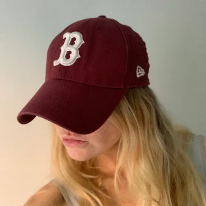 New era-keps, vinröd - Snygg, knappt använd keps (baseball-modell) i vinrött med Brooklynmärket (B) på i strl small/medium. Passar de flesta!