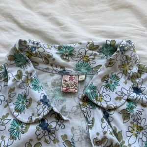 blommig t-shirt/skjorta - en söt blommig tröja med knappar som knäpps fram till. Det står att det är storlek xl men jag skulle säga att det är m