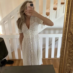 Klänning - Så så söt vit långklänning med gula blommor på från NA-KD💛 Helt oanvänd! (Skriv innan köp!)