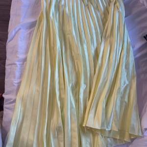 En fin plisserad kjol i satin ifrån zara, använd ett fåtal gånger, den är mycket gulare i verkligheten vilket är svårt att få på bild 
