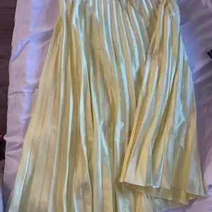 En fin plisserad kjol i satin ifrån zara, använd ett fåtal gånger, den är mycket gulare i verkligheten vilket är svårt att få på bild 