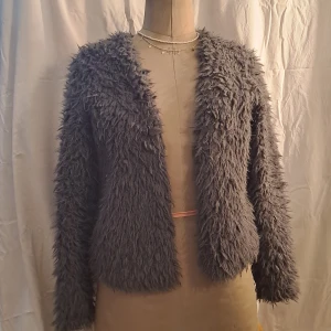 Grå jacka/kofta - Jacka med mjukt fluff på utsidan. Pris är diskuterbart vid snabb affär. 💖. Vid frågor skicka pm. 