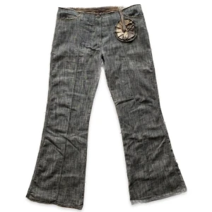 Kostymbyxor - Så nice byxor med liten blomliknande grej framtill. Lappen med märket e borta. 43cm i midjan (mätt rakt över) och 74cm i innerbenslängd. Inte sätt några defekter.