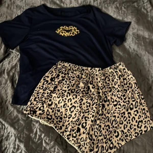 Pyjamas set - Ett blå pyjamas det med leopard mönster på shortsen och på läpp trycket på överdelen.  Använt ett bra tal gånger men är i perfekt skick utan skador.  