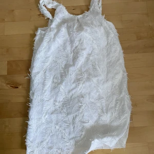 Klänning barn - Vit klänning med fjädrar som mönster för barn. Oanvänd.