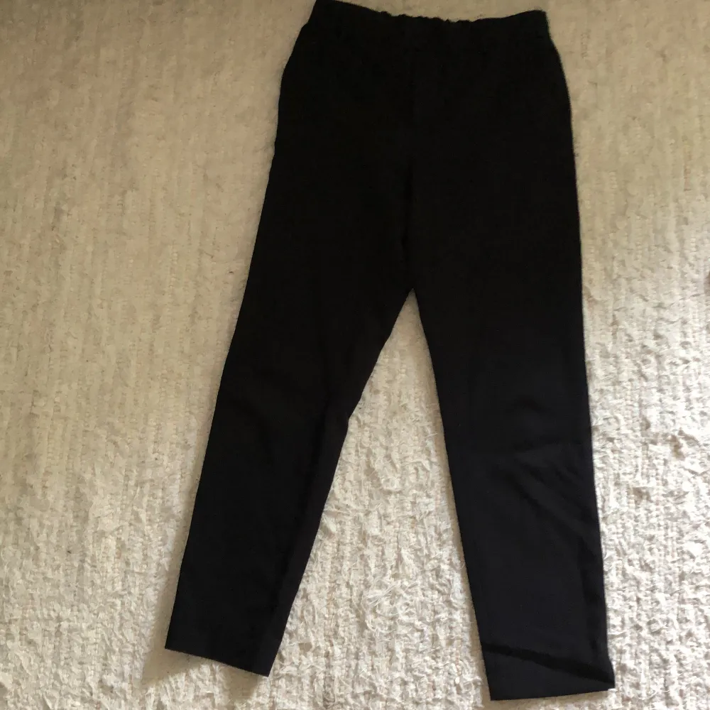 Svarta tygbyxor, som ser ut som kostymbyxor med resår i midjan . Jeans & Byxor.