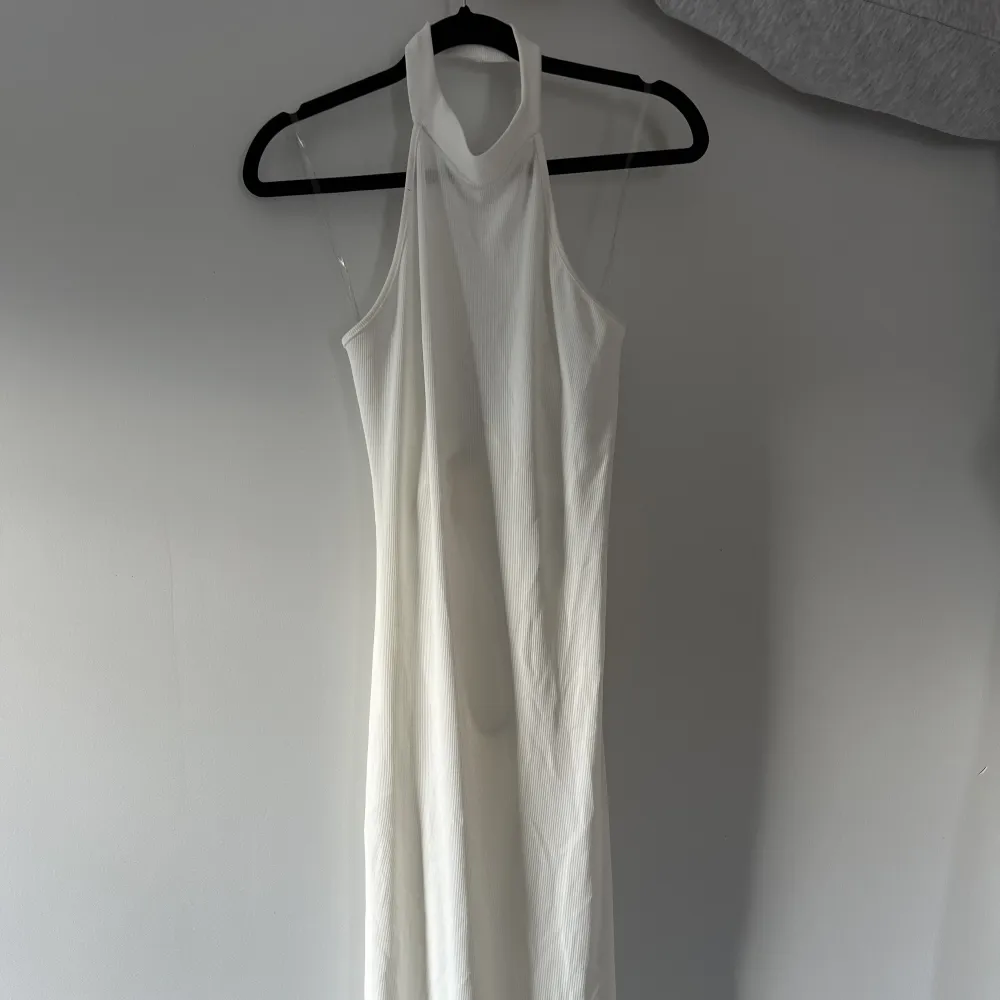 En vit knä-långklänning ifrån FashionNova strl M, sitter figurtight med öppen rygg och knytdetaljer, jättefin att ha en utkväll eller middag!🤍 Säljs för att den inte använts. Klänningar.