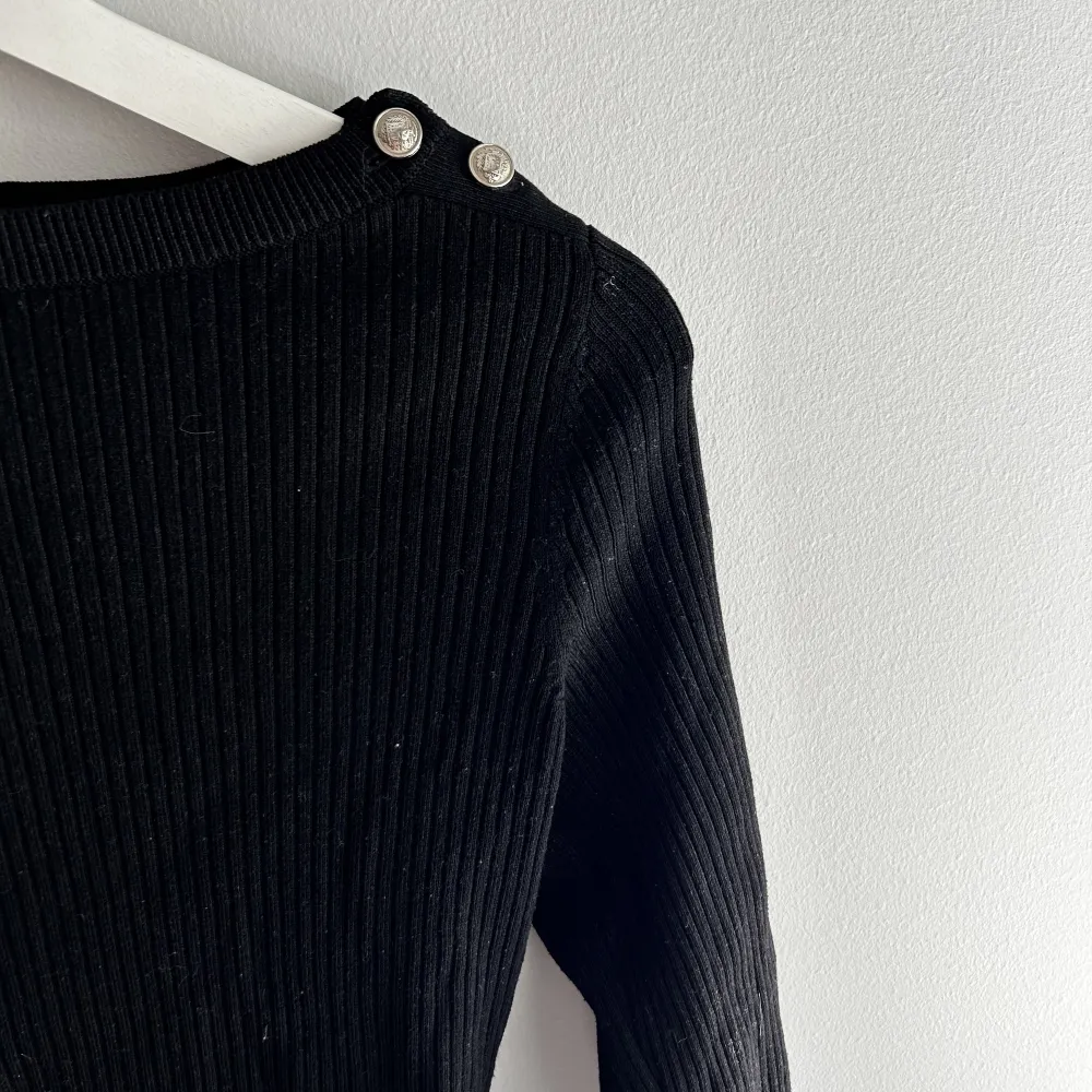 En svart basic tunn stickad tröja med båt krage från HM med jätte fina silvriga knappar på axlarna, den är lite stor i storleken så skulle rekommendera denna för någon som egentligen har xs☺️köparen står för frakt. Toppar.