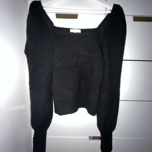 Stickad tröja  - En svart stickad tröja ”med puff på axeln”. I bra skick!!