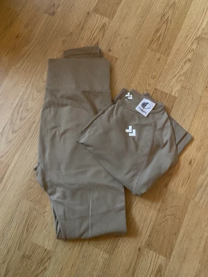 Tränings sett - Snyggt tränings sett 😍 100 för båda plaggen.  Tröjan är storlek L men är liten till storleken. Jag tror att tightsen är i S.