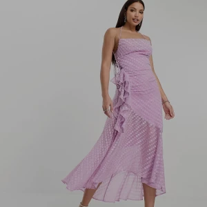 Klänning  - Oanvänd Lila slipklänning i dobbyväv med midilängd, draperad ringning, volang och ojämn fåll