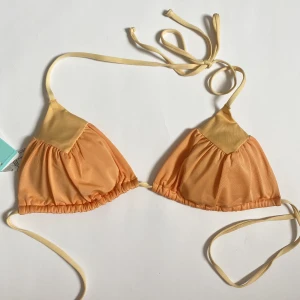 Triangel bikini överdel - Säljer denna trendiga H&M bikini överdel, helt oanvänd med prislappen kvar💛🧡💛